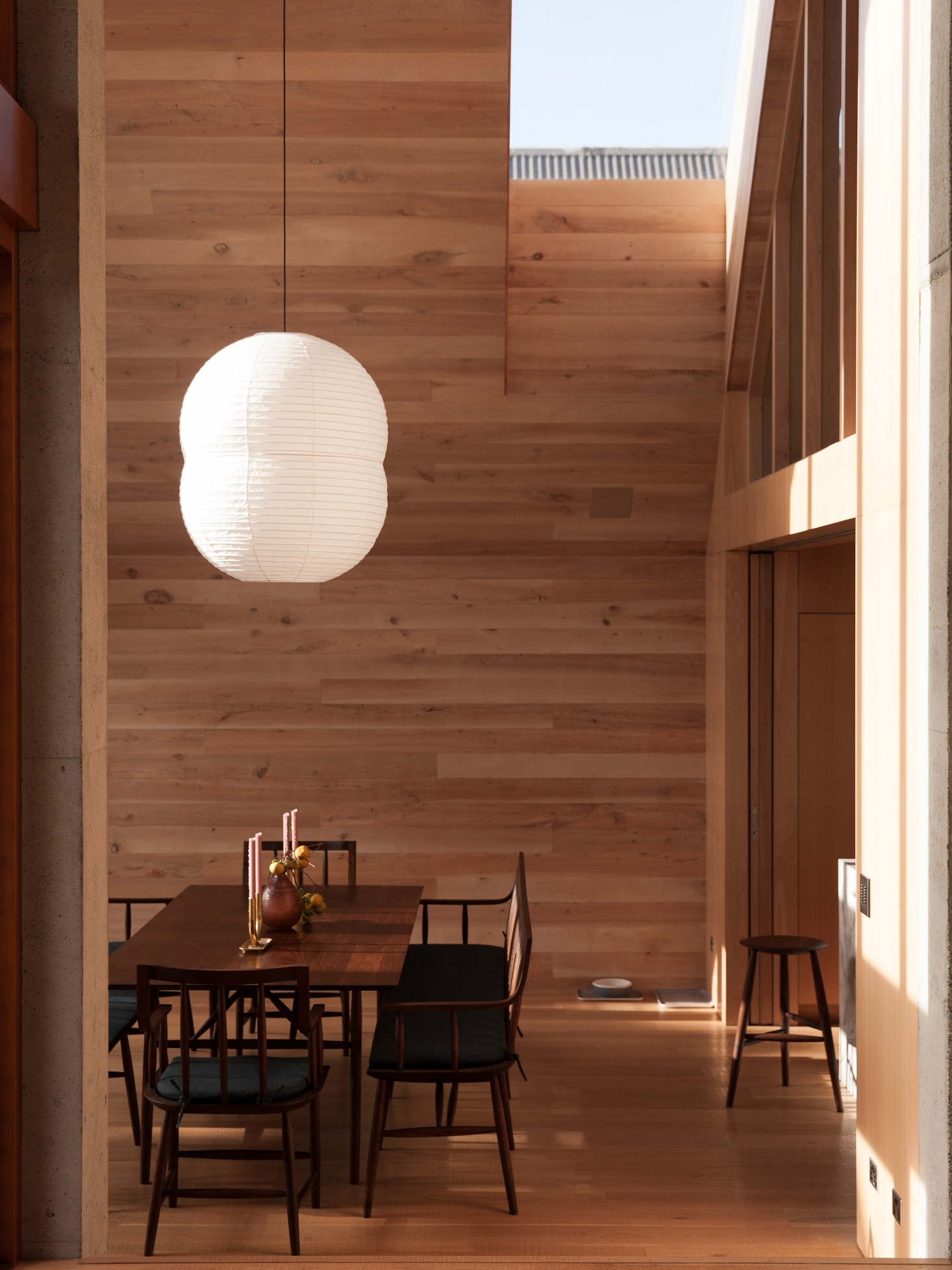 The dining room furniture is by Sawkille in Rhinebeck, New York: the Penn Table, Senate Chair, Senate Bench, and Tall Stool all in American black walnut. The lamp is the Hotaru Double Bubble Light made by Barber & Osgerby for Ozeki & Co. Ltd.—the Japanese manufacturers of Noguchi shades. Photograph by David Straight.