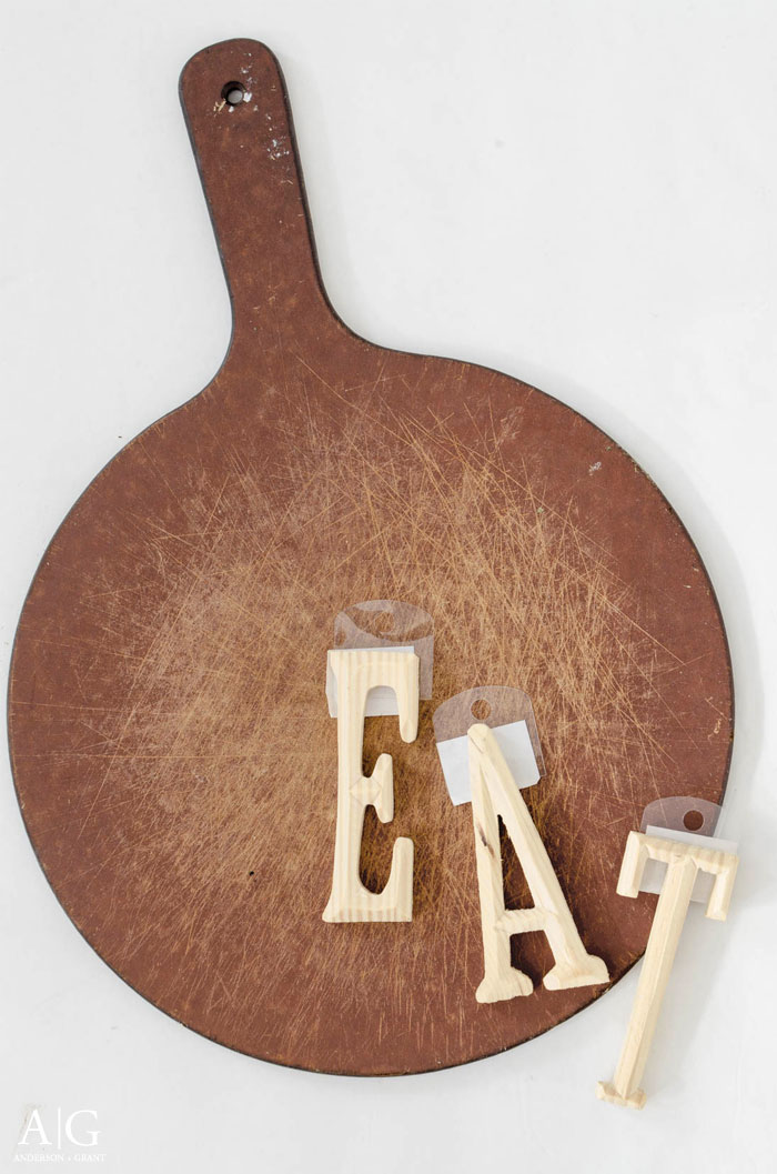An old pizza board and some unfinished letters from Michaels are transformed into some rustic kitchen decor.