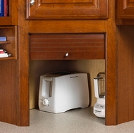 An appliance garage hides your appliances on the countertop behind a wood door.