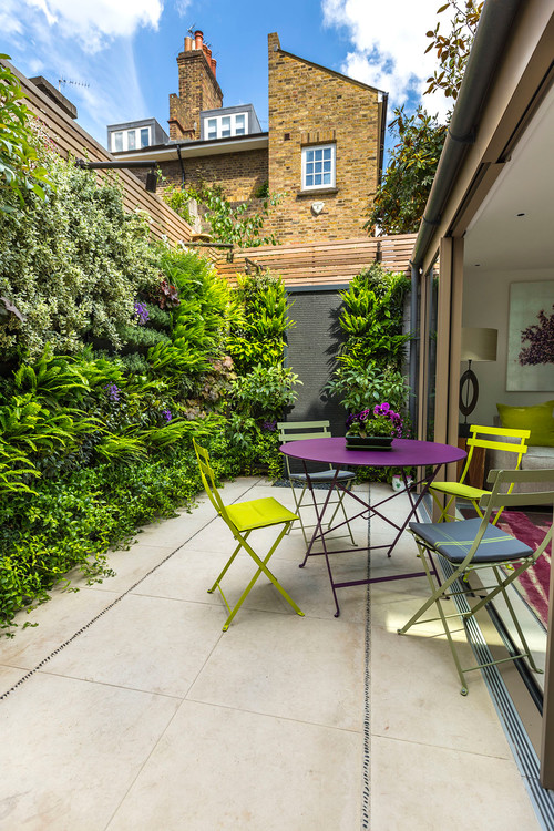 Small outdoor room with a green wall in Kensington