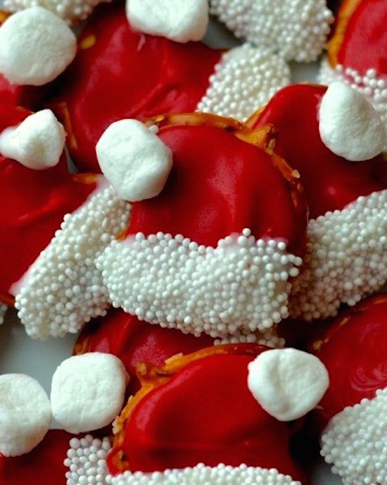 Santa Hat Pretzels! Take some regular shaped pretzels (easy enough), add some red candy melts here, a marshmallow there, and boom! You've got the cutest bite sized Christmas treat to take to the party. 