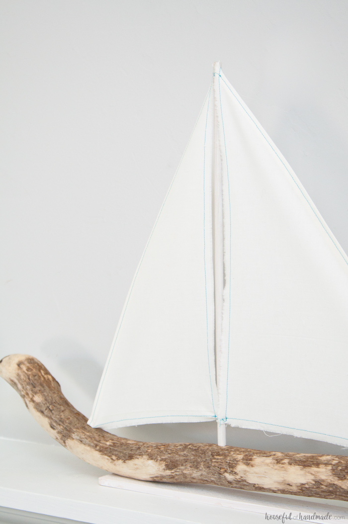 I love coastal decor! If you've ever skipped making your favorite driftwood project because you don't live by the ocean, no need for that anymore. Check out the tutorial for this DIY driftwood sailboat decor and find out where she found driftwood in a land locked state. | Housefulofhandmade.com