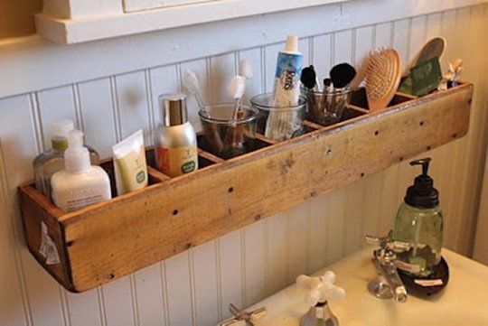 Pequenos nichos de madeira de demolição organizam os cosméticos do banheiro, para quem tem pouco espaço na pia. 