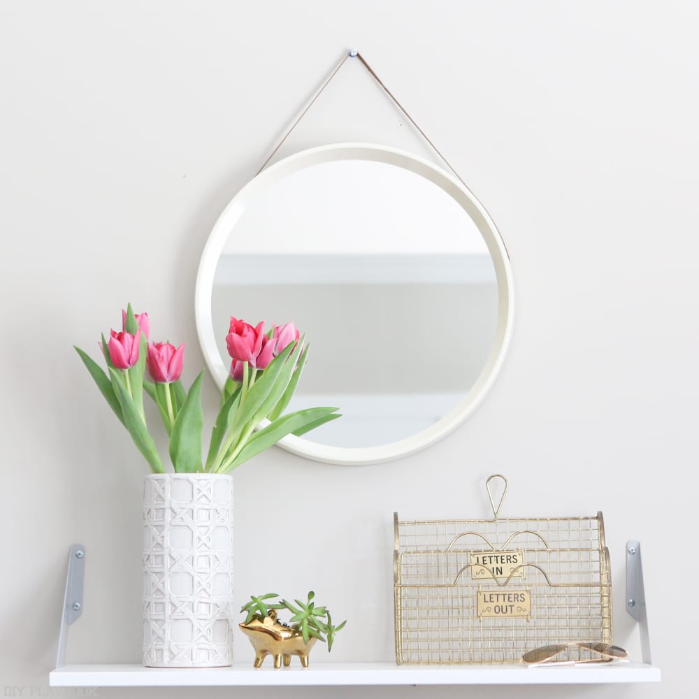 Your entryway can be spruced up with some plants, like these fresh cut tulips and succulent, and a beautiful mirror.